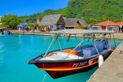 Colorful boat tied up at dock in Bora Bora with turquoise-color water